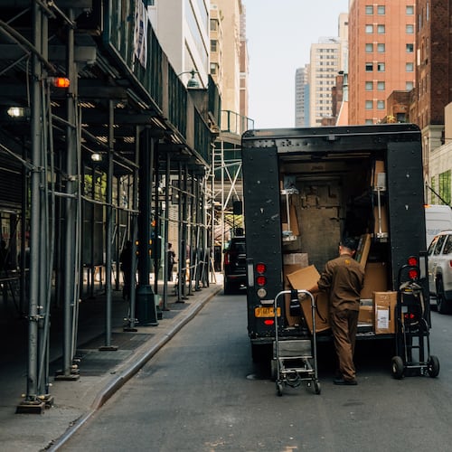 A UPS driver retrieves boxes from the back of his truck, in New York, April 29, 2025. Global shippers like Sandy Springs-based UPS have been left scrambling to adjust in real time to the fast-changing tariff landscape. (DeSean McClinton-Holland/The New York Times)