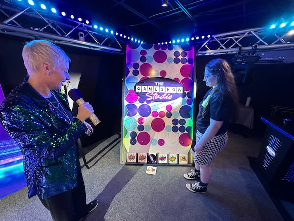 Jen Nittoso (left) serves as a game show host for Maddy Childers at Game Show Studio in downtown Atlanta. “I love bossing people around and telling them they're wrong,” she joked. “It's my passion.” (Rodney Ho/AJC)