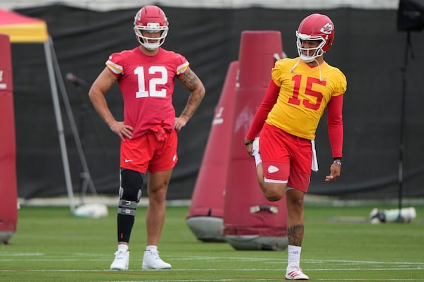 Kansas City Chiefs quarterback Patrick Mahomes (15) and tight end Jared Wiley (12) stretch during the NFL football team's practice Tuesday, June 17, 2025, in Kansas City, Mo. (AP Photo/Charlie Riedel)