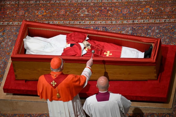 Cardianal Camerlengo Kevin Joseph Farrel asperges the body of late Pope Francis with holy water before closing his casket in St. Peter's Basilica at the Vatican Friday, April 25, 2025. (Vatican Media via AP)