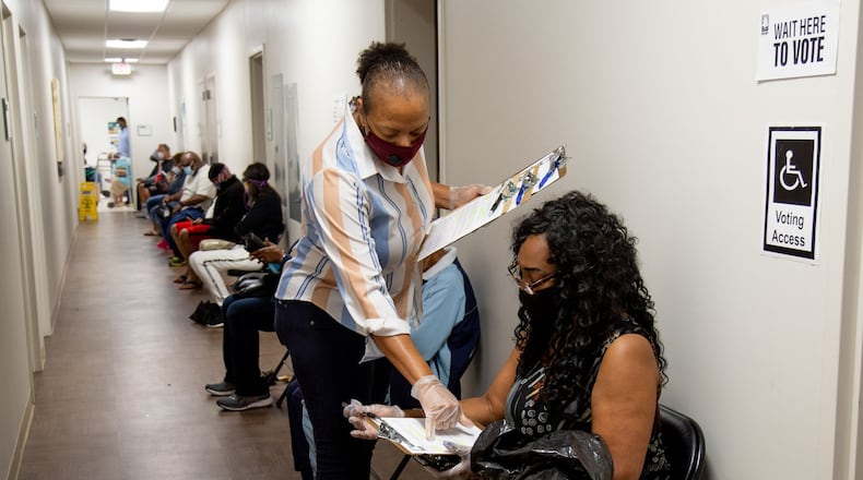 Xavier Benjamin fills out paperwork before voting at the South Fulton Service Center early on Friday morning, May 22, 20220. Benjamin said she arrived at the center at 6:20 am to secure her first place in line. STEVE SCHAEFER FOR THE ATLANTA JOURNAL-CONSTITUTION