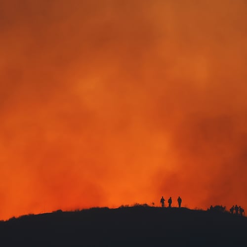 FILE - Firefighters are silhouetted amid an operation to control the Sandy Fire, May 19, 2026, in Simi Valley, Calif. (AP Photo/Caroline Brehman, File)
