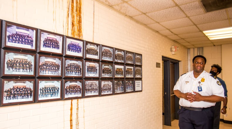 The Atlanta Police Training Academy is housed in a former elementary school and is in disrepair with multiple roof leaks, overflowing sewer pipes and facilities that are outdated and insufficient for police training. The academy class photos of all recruits are posted despite the building’s disrepair. The academy will have to relocate to a temporary facility while waiting for approval to start on the planned training center. (Jenni Girtman for The Atlanta Journal-Constitution)