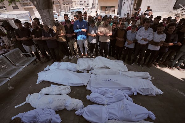 Mourners pray beside the bodies of Palestinians that were killed by an Israeli airstrike that struck a school used as a shelter, in Shifa Hospital in Gaza City, on Thursday, July 3, 2025. (AP Photo/Jehad Alshrafi)