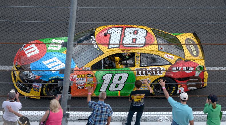 FILE - Kyle Busch waves to fans while doing a victory lap after winning the second of two 150-mile qualifying races for Sunday's NASCAR Daytona 500 auto race at Daytona International Speedway in Daytona Beach, Fla., Feb. 21, 2013. (AP Photo/Phelan M. Ebenhack, File)