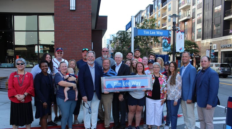 Cobb County officials, Atlanta Braves executives and the family of former Cobb Chairman Tim Lee pose at the dedication of Tim Lee Way in the Battery Atlanta Wednesday.