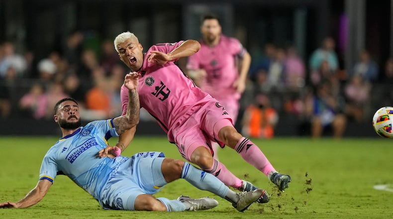 Atlanta United defender Derrick Williams (3) and Inter Miami forward Luis Su·rez (9) fall after kicking the ball during the first half of match one of their MLS playoff opening round soccer match, Friday, Oct. 25, 2024, in Fort Lauderdale, Fla. (AP Photo/Lynne Sladky)