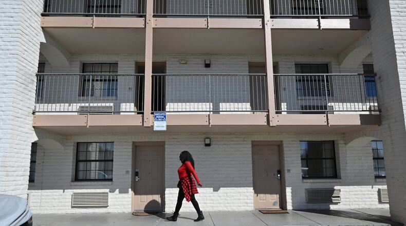 Resident walks below the window of an extended stay motel in Norcross. For low-wage workers, extended stay has been an alternative to homelessness, but many have lost their jobs. (Hyosub Shin / Hyosub.Shin@ajc.com)