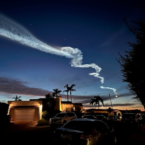 FILE - A contrail from a SpaceX Falcon 9 rocket, which launched from Vandenberg Space Force Base, is seen over homes March 18, 2024, in San Diego. (AP Photo/Gregory Bull, File)