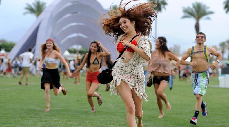 FILE - Festivalgoers run toward the main stage at the Coachella Valley Music and Arts Festival in Indio, Calif., on April 13, 2012. (AP Photo/Chris Pizzello, File)