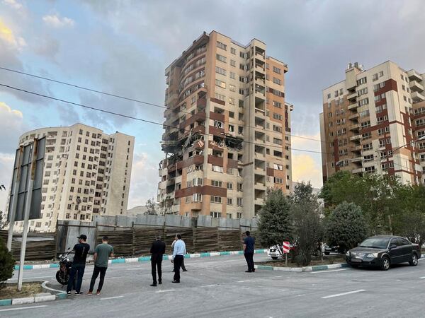 Residents watch a damaged apartment in Tehran, Iran, early Friday, June 13, 2025. Israel attacked Iran's capital early Friday, with explosions booming across Tehran.(AP Photo/Vahid Salemi)