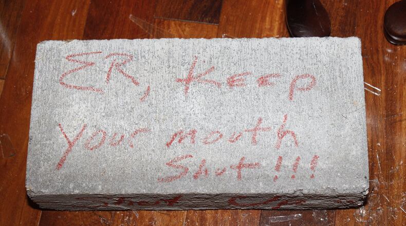 Crime scene photos from the Atlanta Police Department show a brick that landed in Elvin “E.R.” Mitchell Jr’s home in southwest Atlanta in September 2015. Mitchell is a key figure in a federal criminal probe of city of Atlanta contracting.