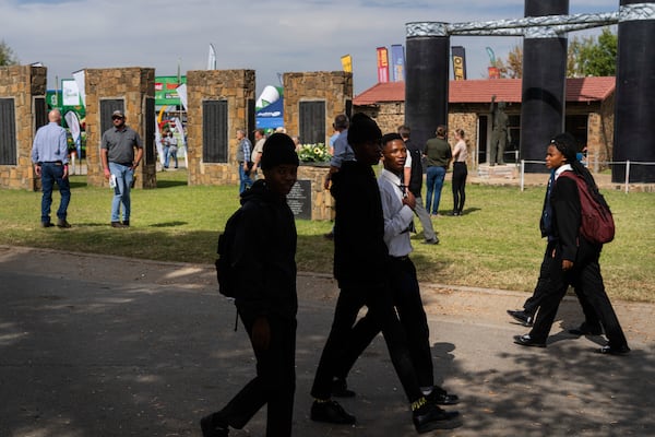 Visitors at the Nampo agricultural fair, one of the largest in the southern hemisphere, walk past the wall of remembrance, a tribute to farmers killed since 1961, near Bothaville, South Africa, May 15, 2025. (AP Photo/Jerome Delay)