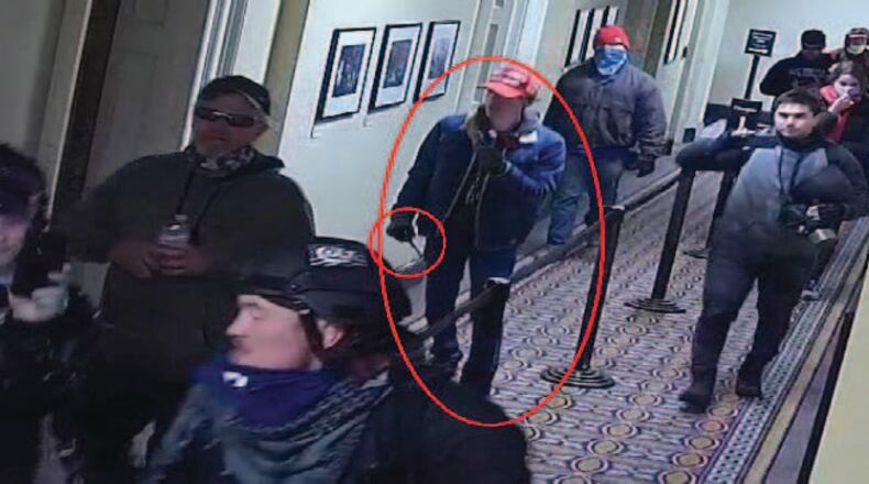 The FBI's criminal complaint against Bruno Cua, 18, of Milton, includes images from U.S. Capitol security cameras that show him carrying what appears to be a baton.