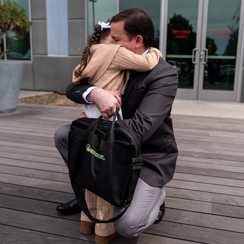 Milenko Faria, whose wife, Dr. Rubeliz Bolivar, is in immigration custody, hugs their daughter, Milena, after his asylum interview at the U.S. Citizenship and Immigration Services facility in Tustin, Calif., Thursday, April 16, 2026. (AP Photo/Jae C. Hong)