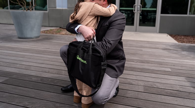 Milenko Faria, whose wife, Dr. Rubeliz Bolivar, is in immigration custody, hugs their daughter, Milena, after his asylum interview at the U.S. Citizenship and Immigration Services facility in Tustin, Calif., Thursday, April 16, 2026. (AP Photo/Jae C. Hong)