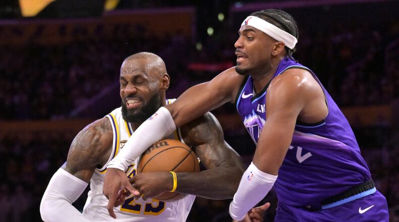 Los Angeles Lakers forward LeBron James, left, is fouled by Utah Jazz forward Blake Hinson (2) as he drives to the basket during the first half of an NBA basketball game Sunday, April 12, 2026, in Los Angeles. (AP Photo/Jayne Kamin-Oncea)
