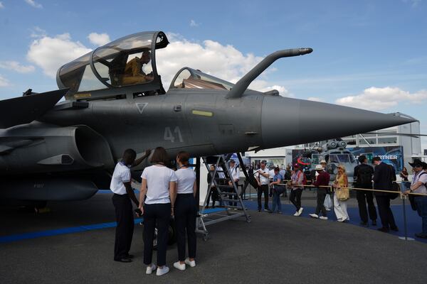 Visitors watch a Rafale fighter jet at the Paris Air Show, Monday, June 16, 2025 in Le Bourget, north of Paris. (AP Photo/Thibault Camus)