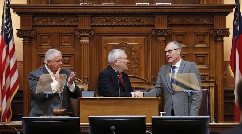Gov. Nathan Deal, center, shakes hands with Lt. Gov. Casey Cagle as House Speaker David Ralston watches after the governor outlined his agenda in his final State of the State speech before a joint session of Georgia’s General Assembly. BOB ANDRES /BANDRES@AJC.COM