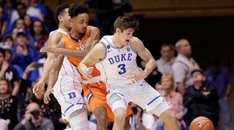 Duke's Frank Jackson, left, and Grayson Allen (3) struggle for possession of the ball with Clemson's Marcquise Reed during the first half of an NCAA college basketball game in Durham, N.C., Saturday, Feb. 11, 2017. (AP Photo/Gerry Broome)