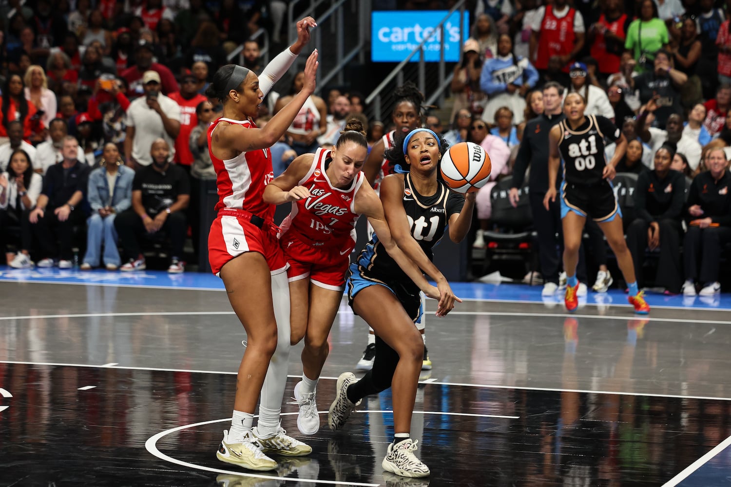 Atlanta Dream forward Angel Reese, right, passes the ball against Las Vegas Aces center A'ja Wilson, left, and forward Stephanie Talbot, center, during the second half of a WNBA game at State Farm Arena on Sunday, May 17, 2026, in Atlanta. (Colin Hubbard for the AJC) 