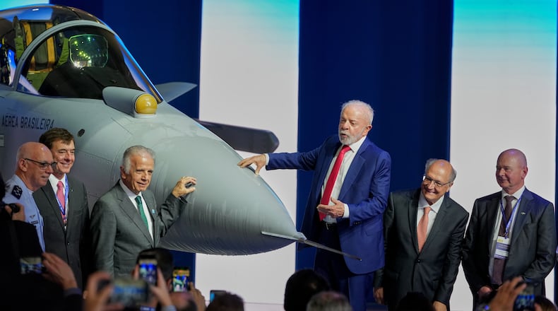 Brazilian President Luiz Inacio Lula da Silva, center, stands next to an F-39E Gripen fighter jet during a ceremony presenting the first supersonic aircraft assembled in Brazil, developed by Saab, at the Embraer plant in Gaviao Peixoto, Brazil, Wednesday, March 25, 2026. From left are Brazilian Air Force Commander Marcelo Kanitz Damasceno, Embraer CEO Francisco Gomes Neto, Defense Minister Jose Mucio, Lula, Vice President Geraldo Alckmin, and Saab CEO Micael Johansson. (AP Photo/Andre Penner)