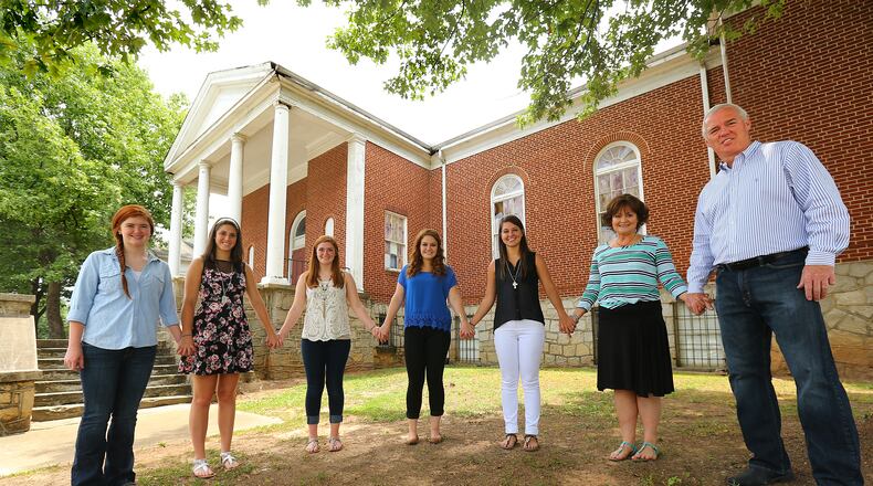 Rev. Bruce Deel and his wife Rhonda with their five daughters (from left) Karli, 12, Kaylin, 18, Kensi, 20, Kelsi, 22, and Kassi, 24, outside their old 14th Street church. CURTIS COMPTON / CCOMPTON@AJC.COM