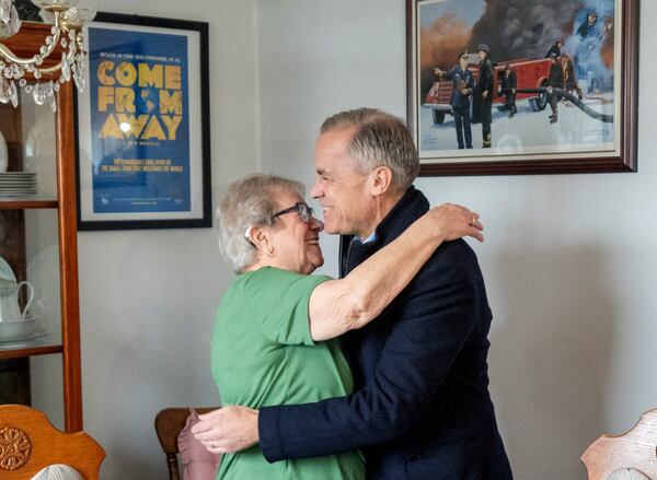 Canada Prime Minister Mark Carney gets a hug from Beulah Cooper as he arrives at her house in Gander, Newfoundland, Canada, Monday, March 24, 2025. (Frank Gunn/The Canadian Press via AP)