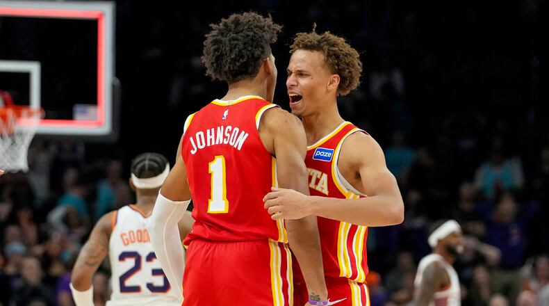 Atlanta Hawks forward Jalen Johnson (1) and Dyson Daniels, right, celebrate comeback win against Phoenix Suns during the second half of an NBA basketball game in Phoenix, Sunday, Nov. 16, 2025. Atlanta won 124-122. (AP Photo/Darryl Webb)