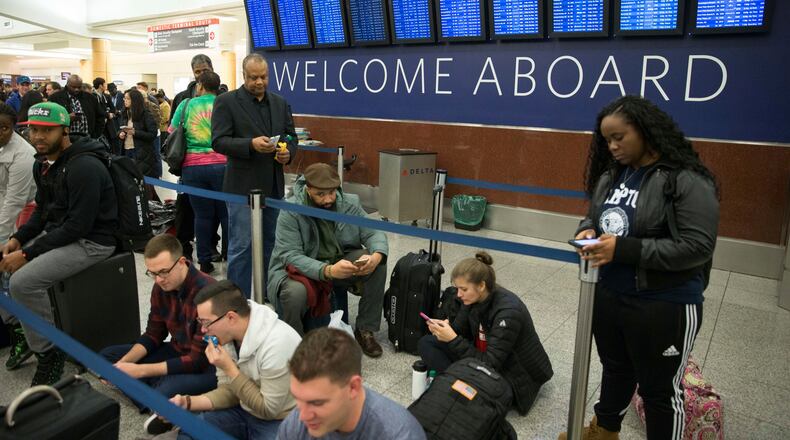Delta passengers wait in line at Hartsfield-Jackson International Airport after Delta Air Lines grounded all domestic flights due to automation issues, Sunday, Jan. 29, 2017, in Atlanta. (AP Photo/Branden Camp)