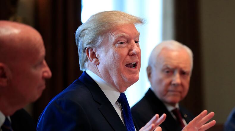 President Donald Trump, flanked by Rep. Kevin Brady, R-Texas, left, and Sen. Orrin Hatch, R-Utah, right, speaks during a bicameral meeting with lawmakers working on the tax cuts in the Cabinet Room of the White House in Washington, Wednesday, Dec. 13, 2017.
