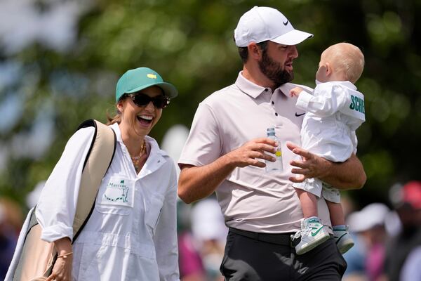 Scottie Scheffler holds his son Bennett as wife Meredith laughs during the par-3 contest at the Masters golf tournament, Wednesday, April 9, 2025, in Augusta, Ga. (AP Photo/George Walker IV)