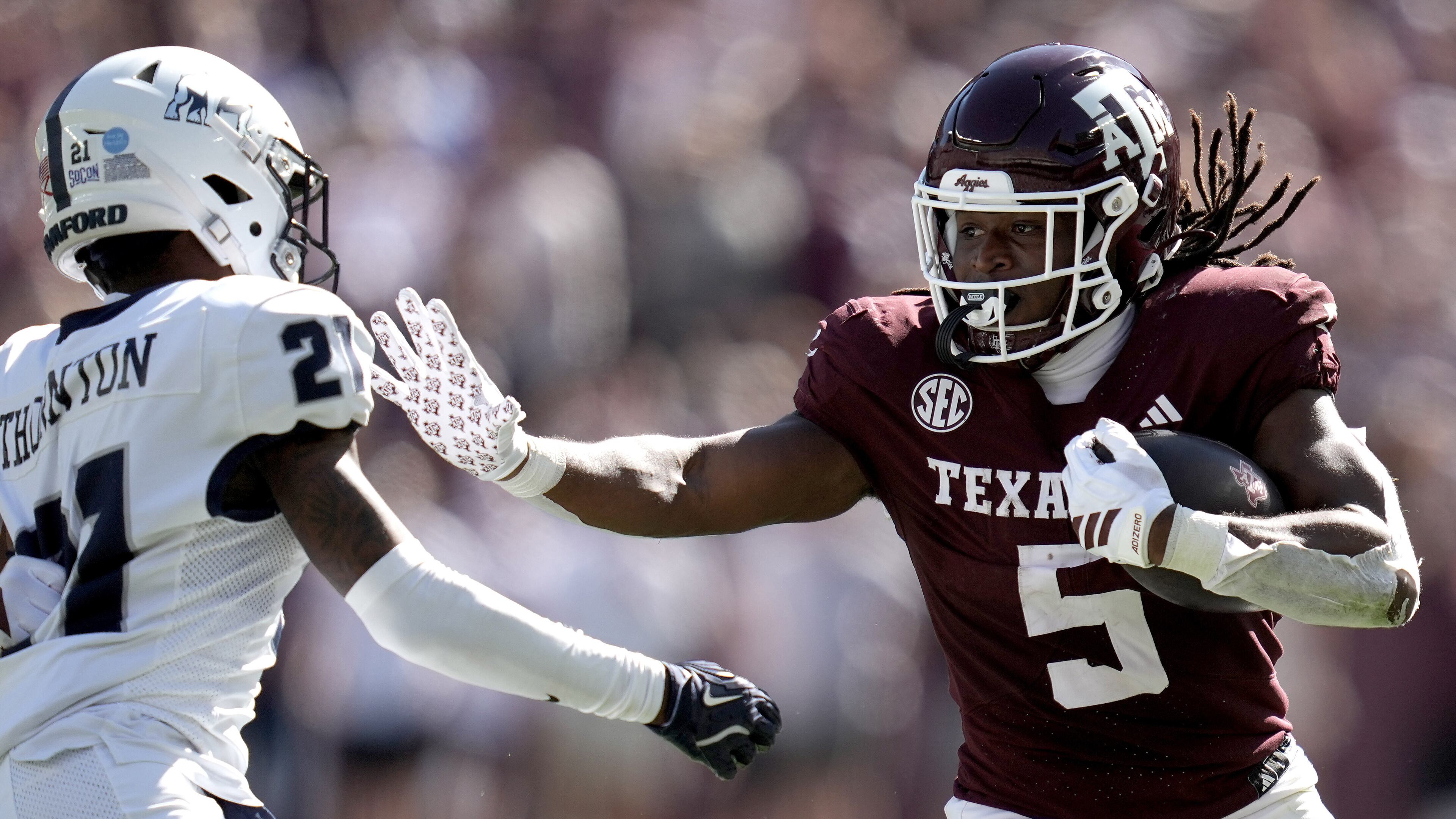 Texas A&M running back Amari Daniels (5) stiff arms Samford cornerback Malik Thornton (21) during a long run from scrimmage during the second quarter of an NCAA college football game Saturday, Nov. 22, 2025, in College Station, Texas. (AP Photo/Sam Craft)