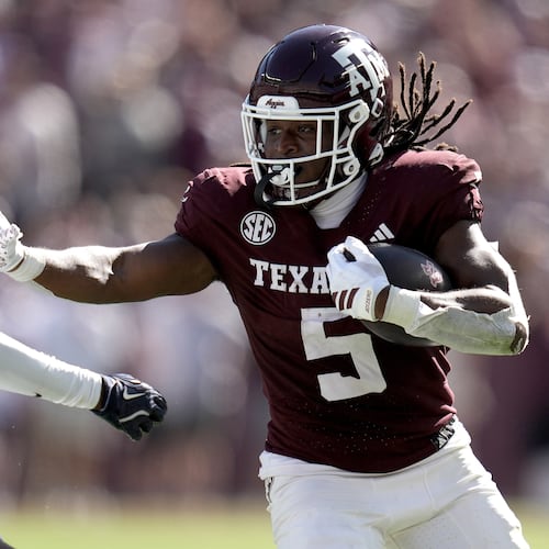 Texas A&M running back Amari Daniels (5) stiff arms Samford cornerback Malik Thornton (21) during a long run from scrimmage during the second quarter of an NCAA college football game Saturday, Nov. 22, 2025, in College Station, Texas. (AP Photo/Sam Craft)