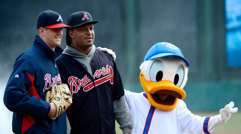 Donald Duck gets in on an the action as former Georgia football player Jarvis Jones (center) poses for a photo with Braves and former Bulldogs pitcher Alex Wood after Jones threw out the ceremonial first pitch to Wood before an exhibition spring training baseball game against the Detroit Tigers Sunday, March 3, 2013.