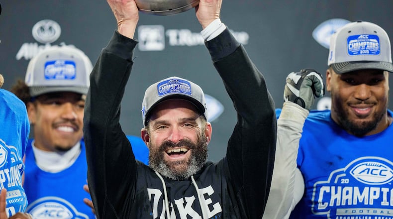FILE - Duke head coach Manny Diaz holds up the trophy after defeating Virginia in the Atlantic Coast Conference championship NCAA college football game, Dec. 6, 2025, in Charlotte, N.C. (AP Photo/Jacob Kupferman, File)
