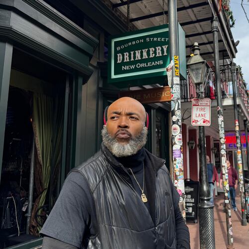 Miguel Thornton stands under memorial flags for the victims of a Jan. 1, 2025, vehicle ramming attack, outside of the Bourbon Street bar, where he works, on Monday, Dec. 29, 2025, in New Orleans. (AP Photo/Jack Brook)