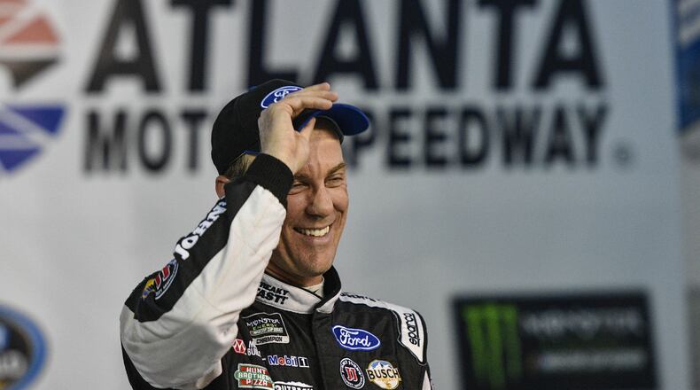 Kevin Harvick stands in Victory Lane after winning the pole for the NASCAR Monster Energy Cup auto race at Atlanta Motor Speedway in Hampton, Ga., Friday, March 3, 2017. (AP Photo/John Amis)