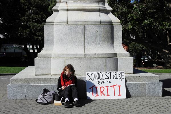 A student opposing the Principles of the Treaty of Waitangi Bill sits outside New Zealand's Parliament in Wellington, New Zealand, Thursday, April 10, 2025.(AP Photo/ Charlotte Graham-McLay)