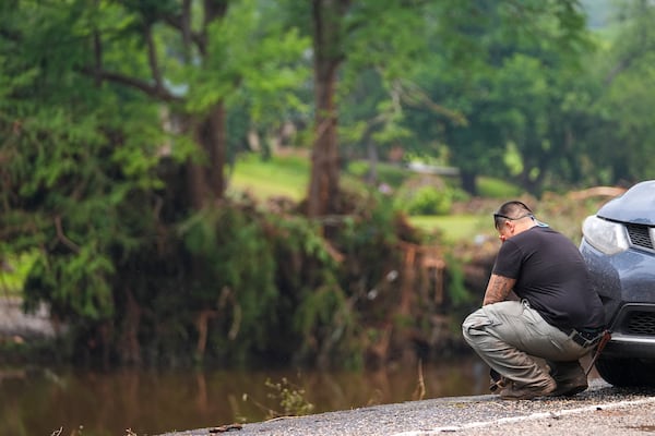 Avi Santos, 23, of San Antonio, Texas, reacts while stopping on the road alongside at Camp Mystic along the banks of the Guadalupe River after a flash flood swept through the area Sunday, July 6, 2025, in Hunt, Texas. (AP Photo/Julio Cortez)