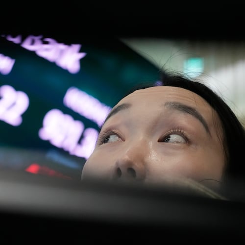 A currency trader watches monitors near a screen showing the Korea Composite Stock Price Index (KOSPI) at the foreign exchange dealing room of the Hana Bank headquarters in Seoul, South Korea, Wednesday, July 1, 2026. (AP Photo/Ahn Young-joon)