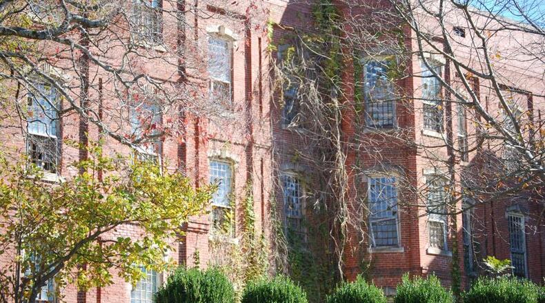 Unkempt vines and weeds crawl up the brick exterior walls of the Walker Building at Central State Hospital in Milledgeville. Central State once housed as many as 12,000 people. Now, the only unit that remains is one for people committed through the criminal justice system.