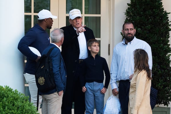 President Donald Trump with his grandson, Theodore Kushner, fourth from left, talks to Philadelphia Eagles football player Saquon Barkley, left, and other guests as he arrives at the White House, Sunday, April 27, 2025, in Washington. (AP Photo/Manuel Balce Ceneta)