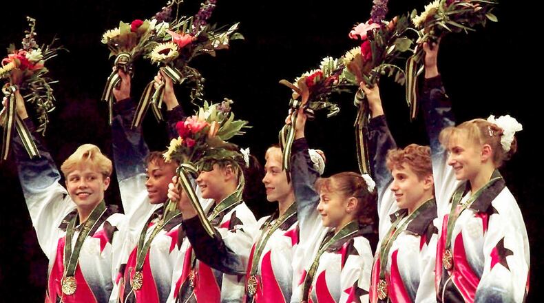 Members of the United States women's gymnastics team - Amanda Borden (from left), Dominique Dawes, Amy Chow, Jaycie Phelps, Dominique Moceanu, Kerri Strug, and Shannon MIller - wave to the crowd after being awarded their gold medals in the team competition of the 1996 Olympic Games Tuesday, July 23, 1996, at the Georgia Dome in Atlanta. (John Gaps III/AP)