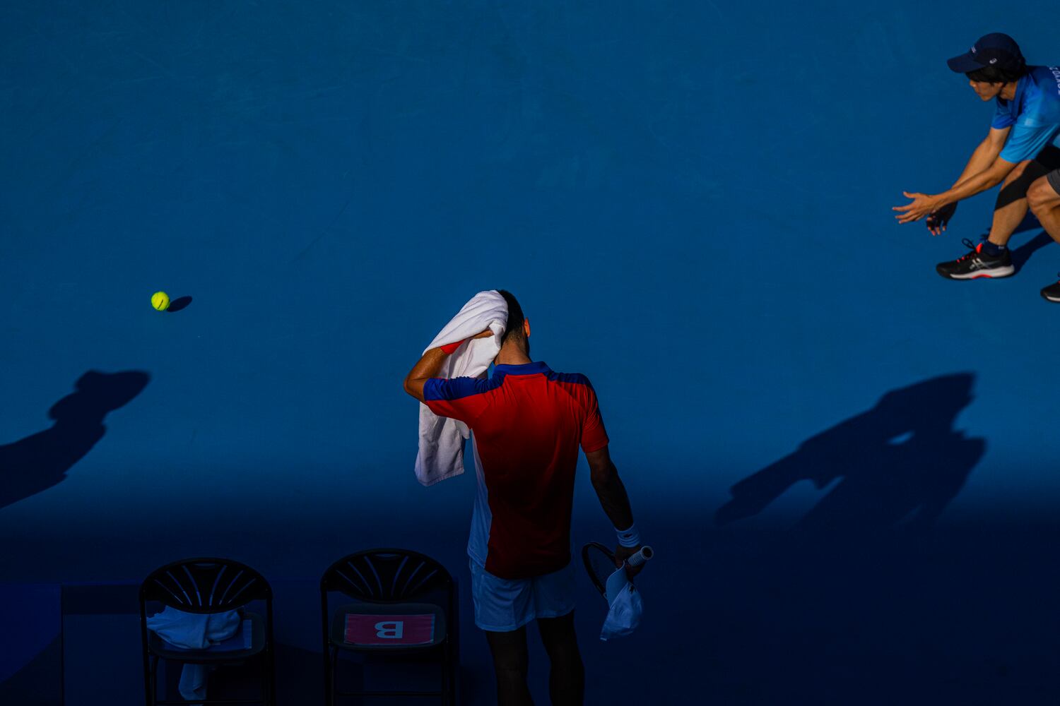 Novak Djokovic of Serbia uses a towel to wipe his head during his match against Hugo Dellien of Bolivia at the postponed 2020 Tokyo Olympics in Tokyo on July 24, 2021. (Hiroko Masuike/The New York Times)