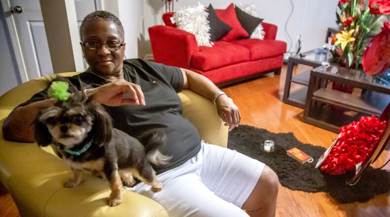 Marcia Body sits in her Jonesboro home with her dog Dora. Body, a cancer survivor, said she had to improvise a face mask when COVID-19 hit the Clayton County Jail. (STEVE SCHAEFER FOR THE ATLANTA JOURNAL-CONSTITUTION)