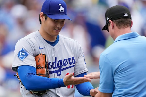 Los Angeles Dodgers starting pitcher Shohei Ohtani is checked by third base umpire Alex Tosi after pitching in the first inning of a baseball game against the Kansas City Royals, Saturday, June 28, 2025, in Kansas City, Mo. (AP Photo/Charlie Riedel)