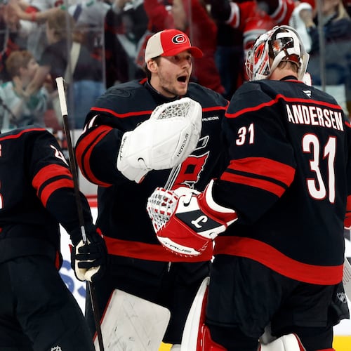 Carolina Hurricanes goaltender Brandon Bussi (32) congratulates goaltender Frederik Andersen (31) with William Carrier (28), following the second overtime of Game 2 of an NHL hockey Stanley Cup first-round playoff series against the Ottawa Senators in Raleigh, N.C., Monday, April 20, 2026. (AP Photo/Karl DeBlaker)