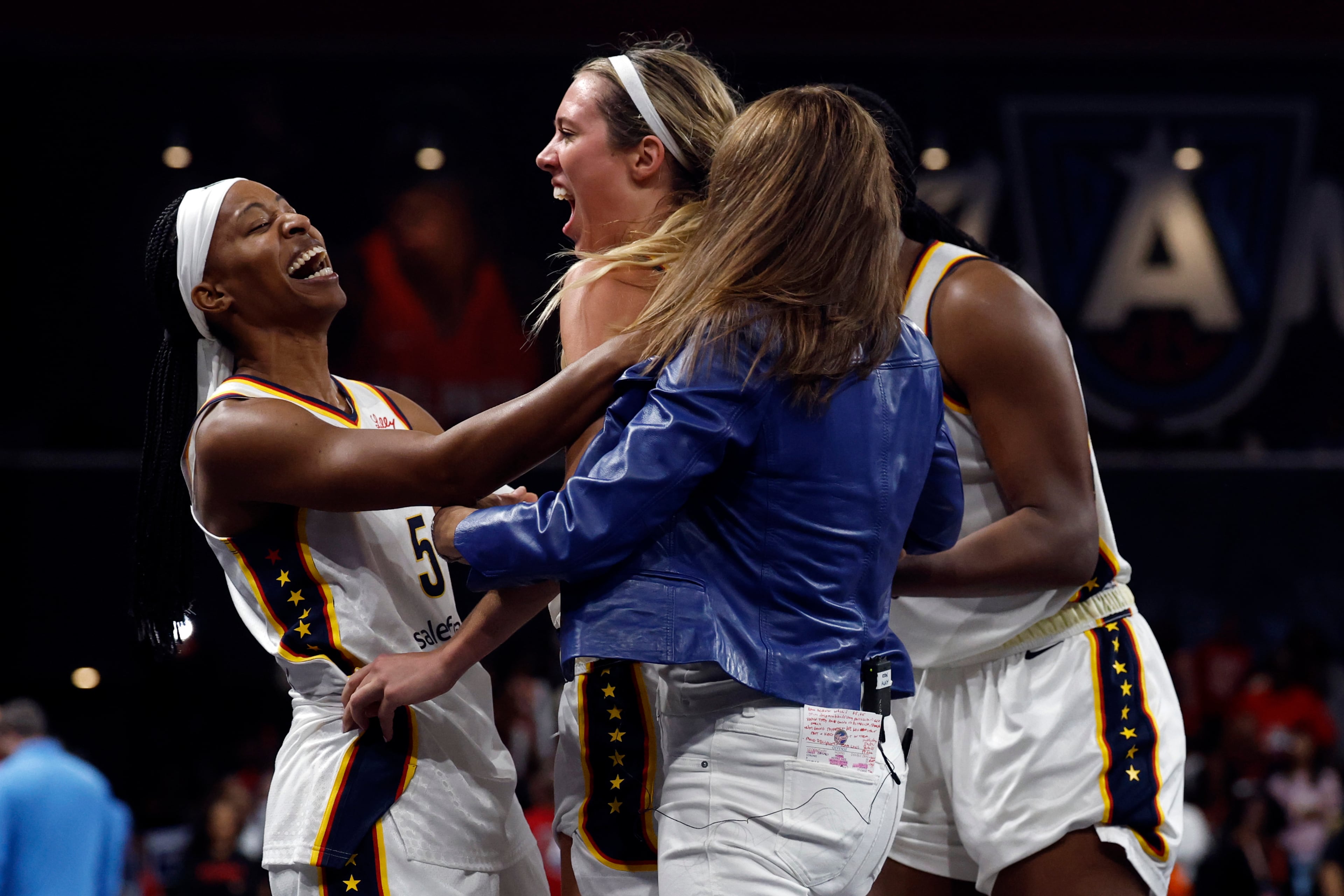 Indiana Fever guard Shey Peddy (5), guard Lexie Hull, center left, and head coach Stephanie White, center right, celebrate after a score to take the lead over the Atlanta Dream during the second half of Game 3 in the first round of the WNBA basketball playoffs, Thursday, Sept. 18, 2025, in Atlanta. (AP Photo/Butch Dill)