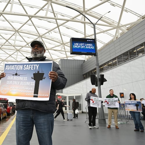 John Love holds a sign with other union members of the Professional Aviation Safety Specialists union at Hartsfield-Jackson Atlanta International Airport's domestic terminal, Wednesday, October 29, 2025, in Atlanta. PASS members at the Federal Aviation Administration (FAA), working without pay or furloughed, held an informational picket at Hartsfield-Jackson to call public attention to the impact of the government shutdown on aviation safety and the personal toll it is taking on their families. (Hyosub Shin/AJC)